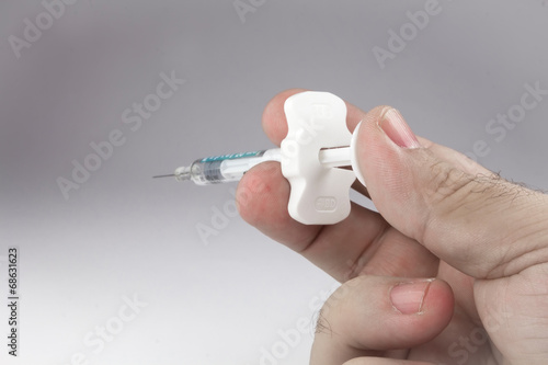 Hand with a syringe in position to inject