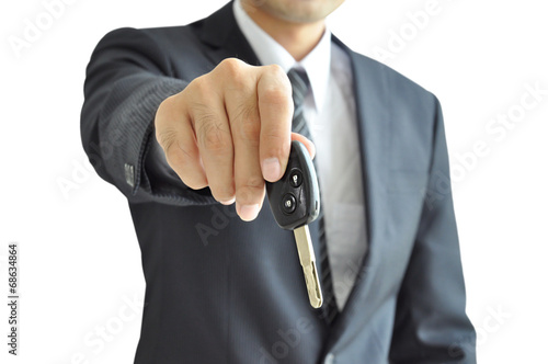 Businessman hand holding a car key on white background