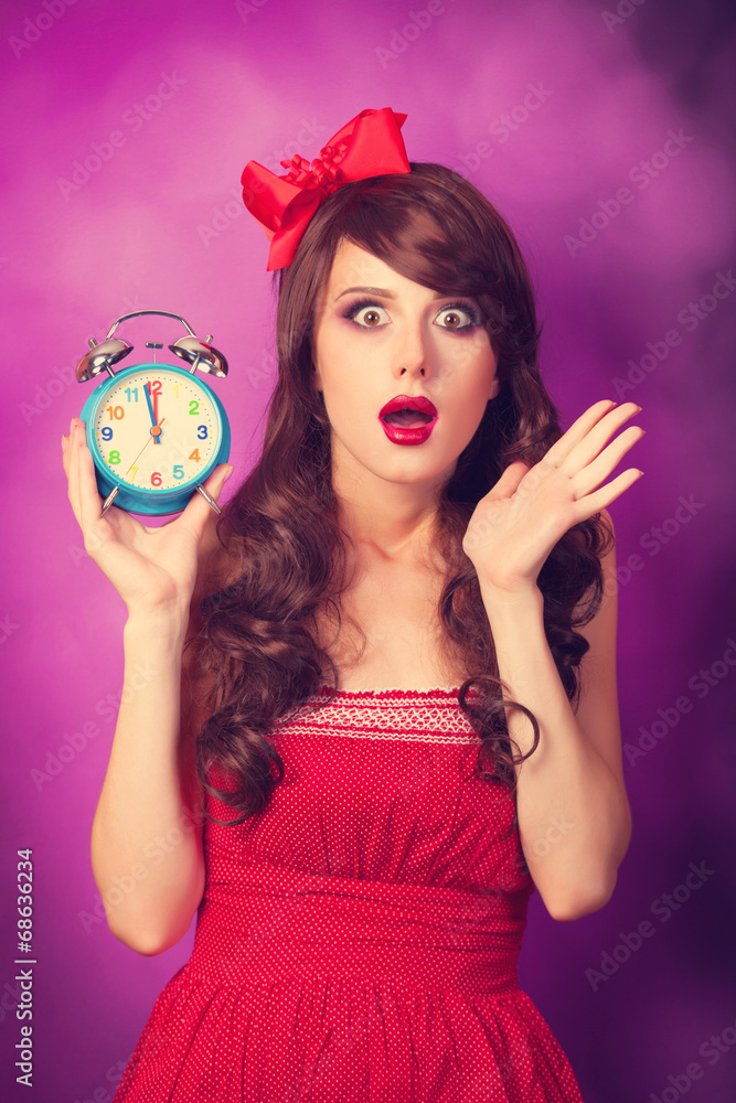 Surprised girl with alarm clock on violet background. Surprised girl with alarm clock on violet background.
