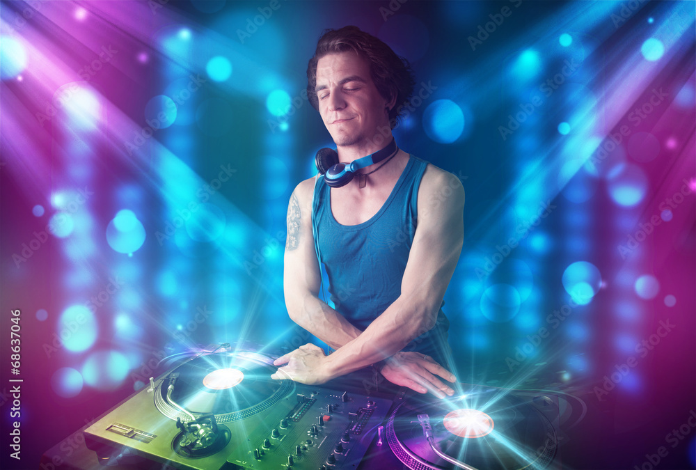 Dj mixing music in a club with blue and purple lights - obrazy, fototapety, plakaty 
