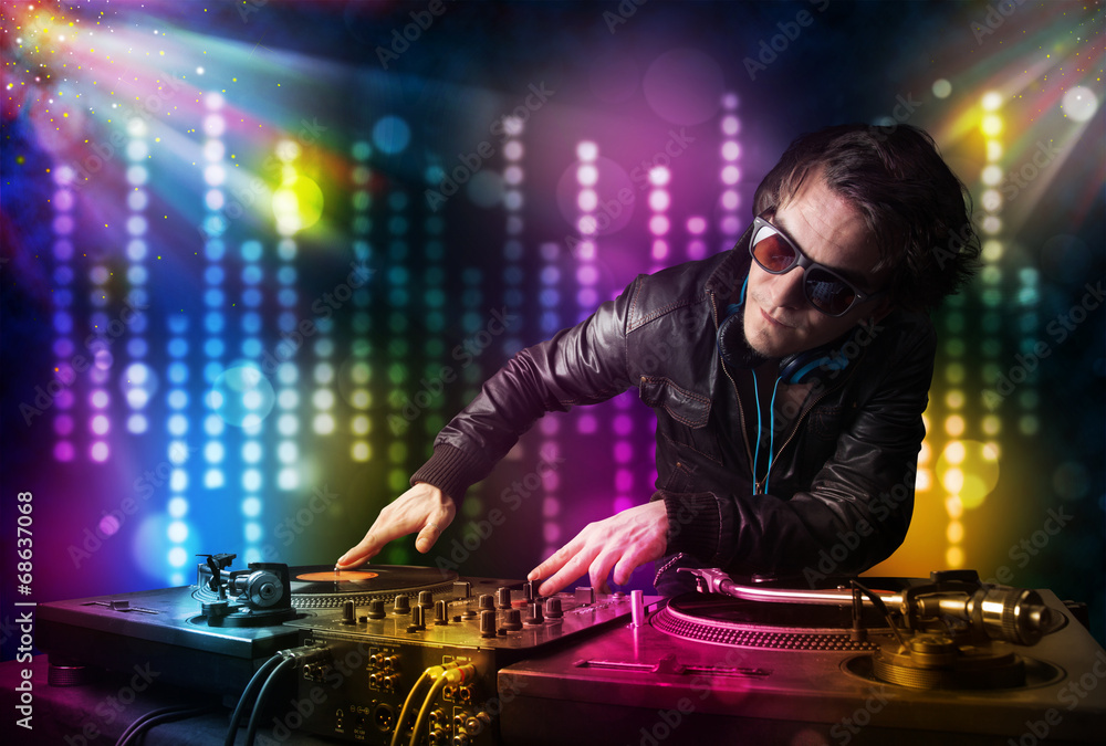 Dj playing songs in a disco with light show - obrazy, fototapety, plakaty 