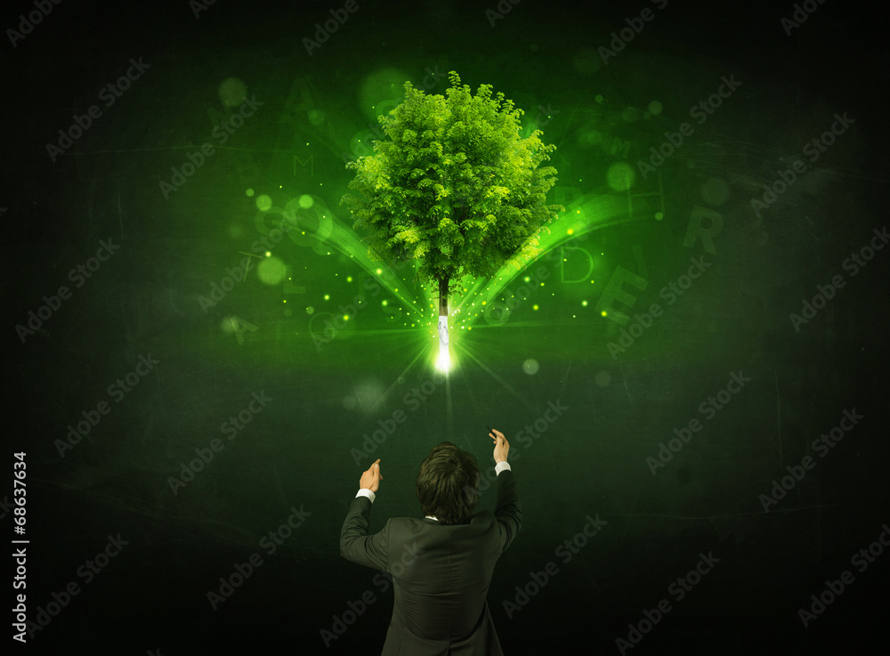 Businessman gesturing in front of a glowing tree