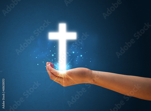 Fototapeta Naklejka Na Ścianę i Meble -  Glowing cross in the hand of a woman