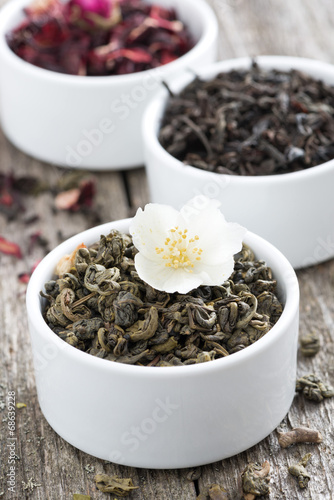 Assorted dry herbal teas in white bowls, close-up