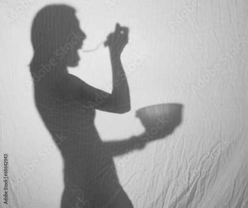 A female silhouette eating