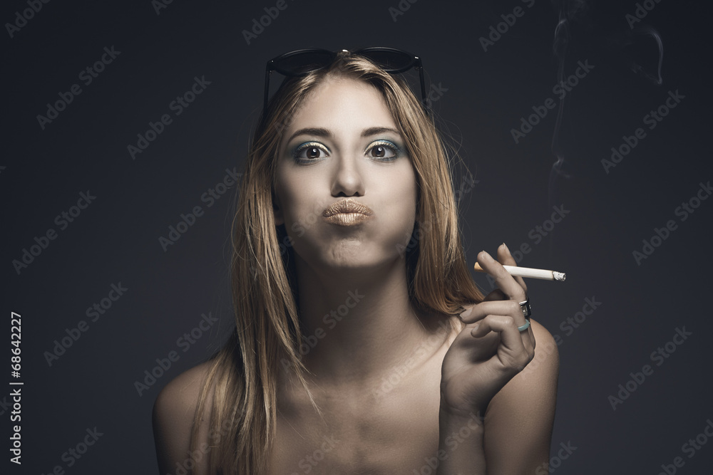 Funny portrait of young sexy woman while smoking a cigarette Stock Photo |  Adobe Stock
