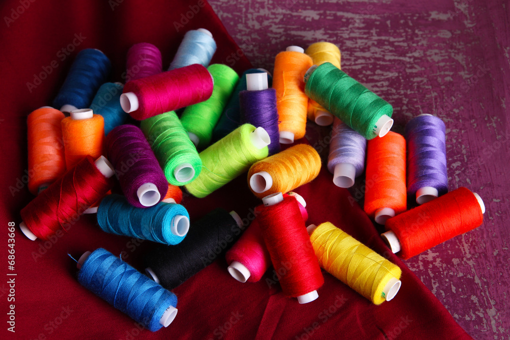Multicolor sewing threads on wooden background Multicolor sewing threads on wooden background