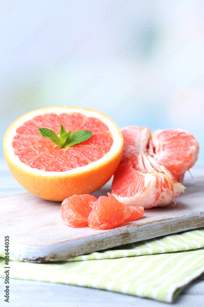 Ripe grapefruits on cutting board, on wooden background Ripe grapefruits on cutting board, on wooden background