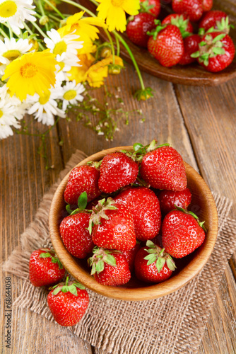 Ripe sweet strawberries in bowl on table close-up