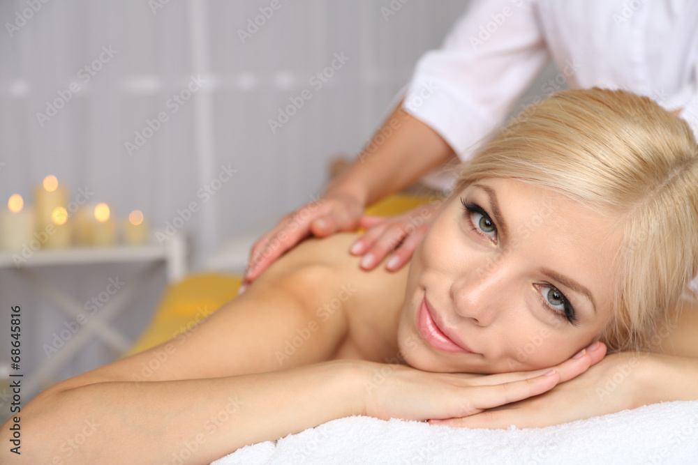 Beautiful young woman having massage in spa salon