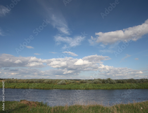 View to river with reflections and blue cloudy sky © areporter