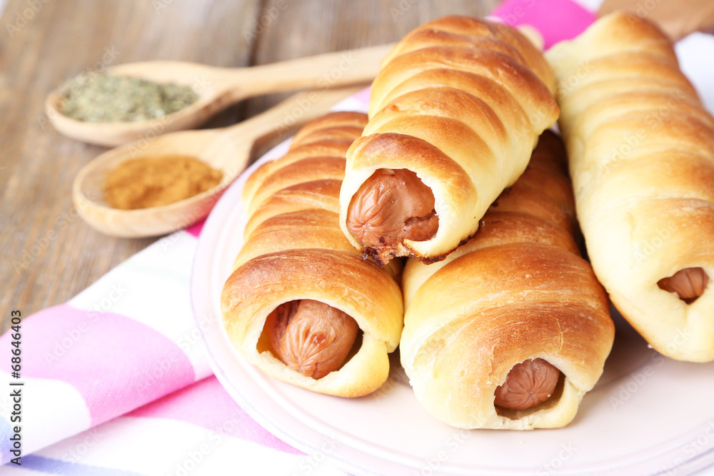 Baked sausage rolls on plate on table close-up Baked sausage rolls on plate on table close-up