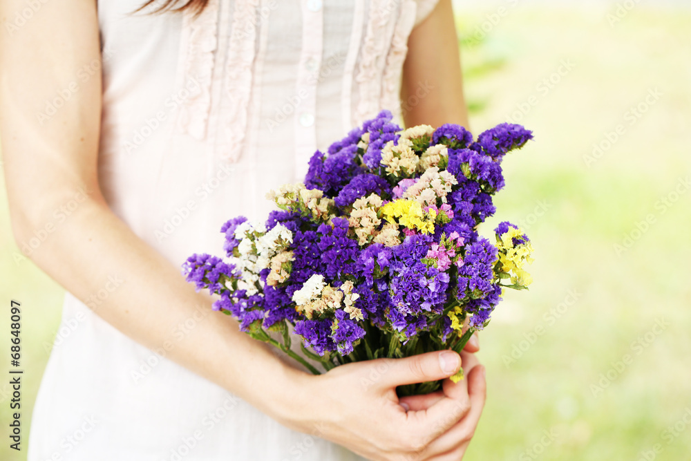 Wildflowers in hands of girl on natural background Wildflowers in hands of girl on natural background