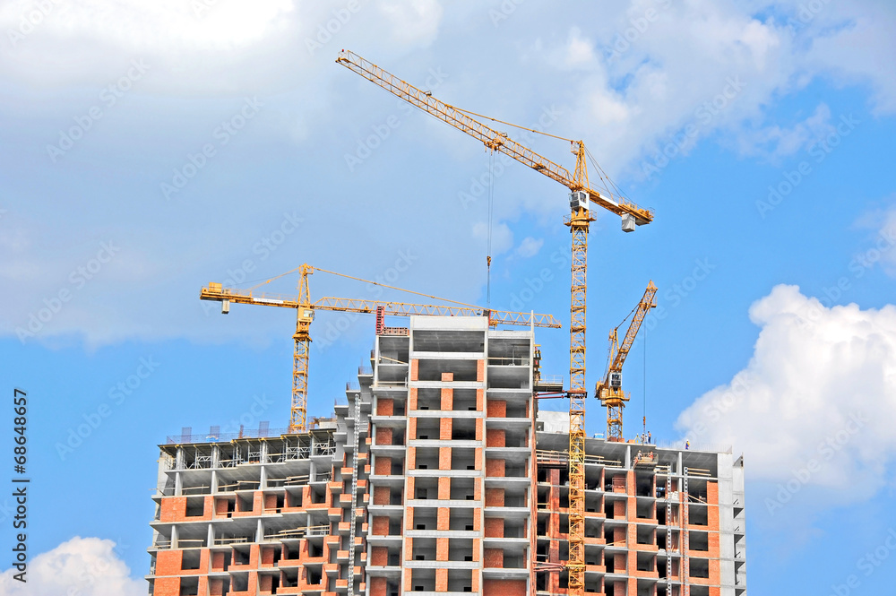 Crane and building construction site against blue sky Crane and building construction site against blue sky