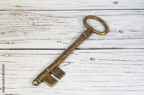 Antique key on wooden background © aguadeluna