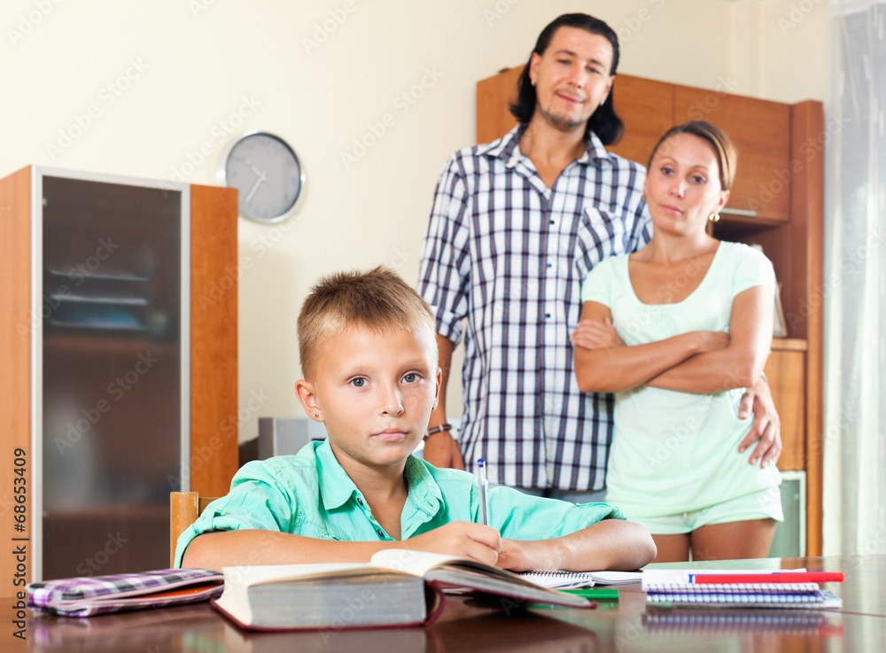 Fototapeta premium parents watching their son doing homework