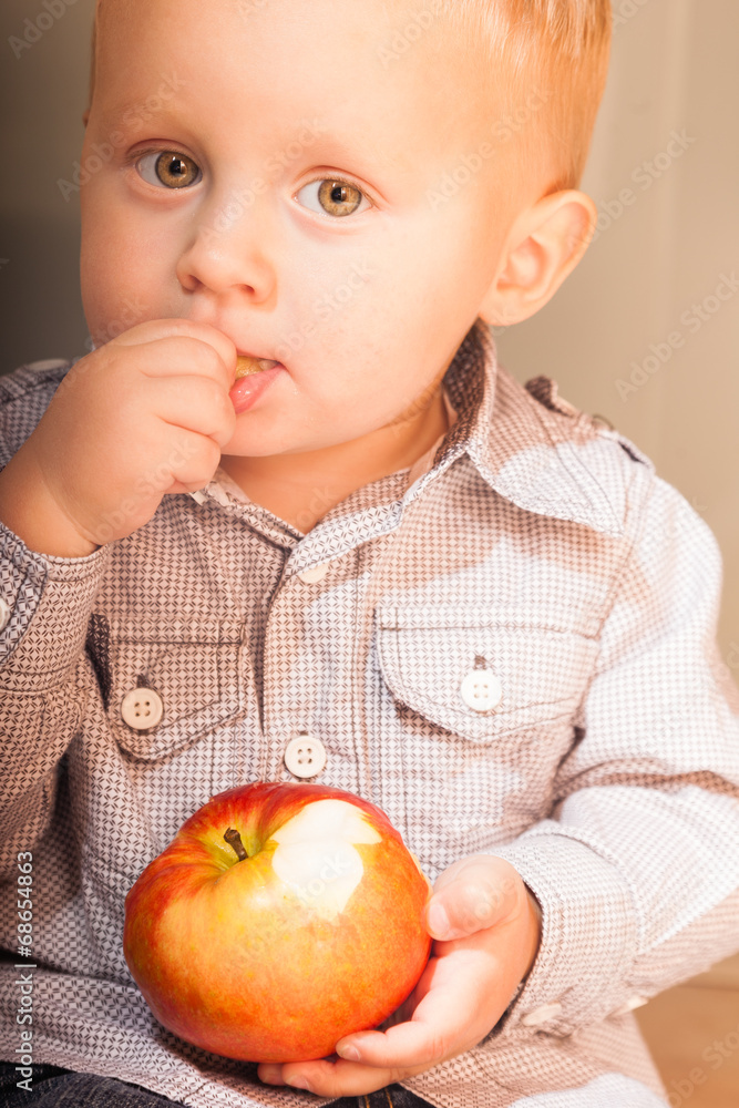 Little boy child kid eating apple fruit at home Little boy child kid eating apple fruit at home