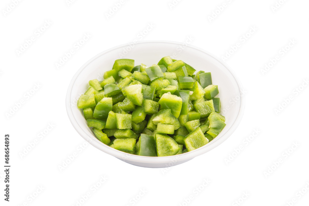 Chopped green capsicums in white bowls over white background Chopped green capsicums in white bowls over white background