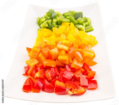 Colorful chopped capsicums in a plate over white background 