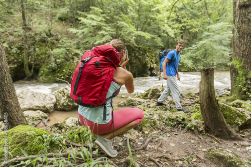 Young woman taking photo of man at hiking