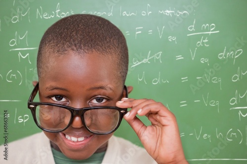 Composite image of cute pupil tilting glasses