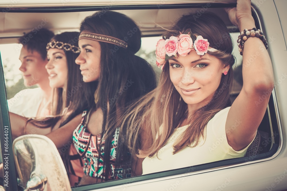 Multi-ethnic hippie friends in a minivan on a road trip - obrazy, fototapety, plakaty 