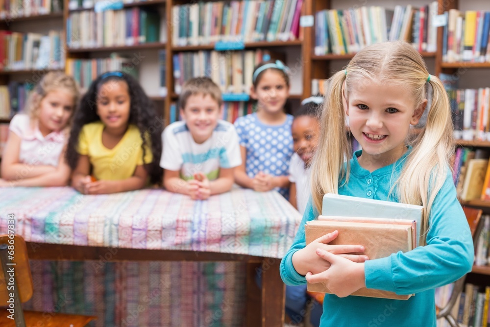 Cute pupils looking at camera in library Cute pupils looking at camera in library