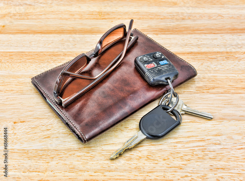 Sunglasses and car keys with leather wallet