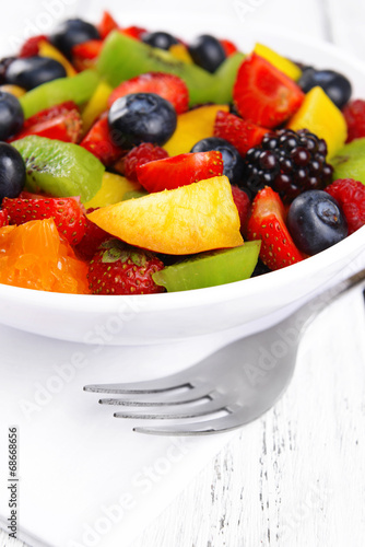 Delicious fruits salad in plate on table close-up