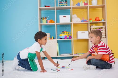 Fotografie Cute little boys painting on floor in classroom