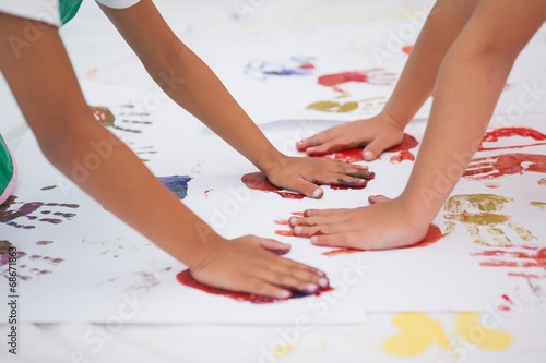 Cute little boys painting on floor in classroom