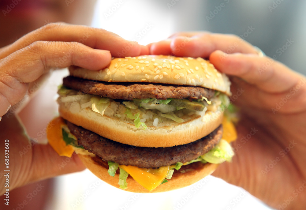 man's hands, holding onto a burger man's hands, holding onto a burger