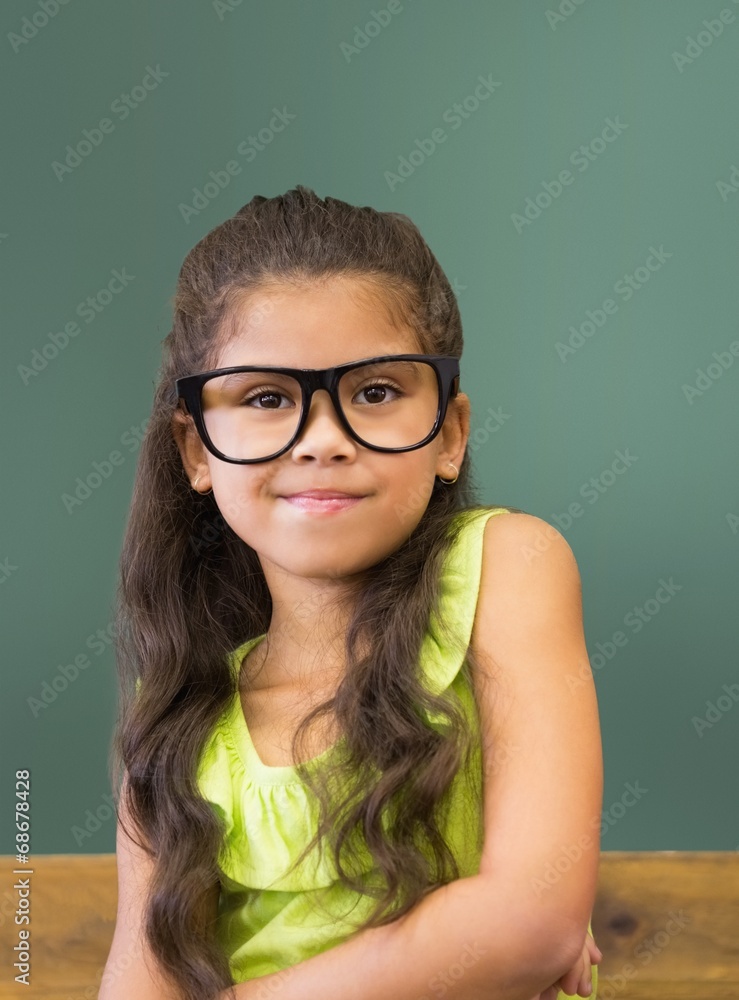Cute pupil smiling at camera in classroom