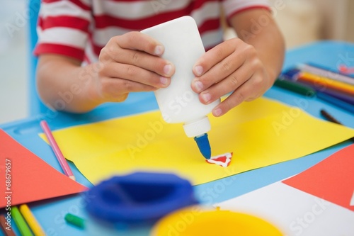 Cute little boy making art in classroom