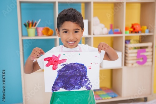 Obraz na plátně Cute little boy showing his painting in classroom