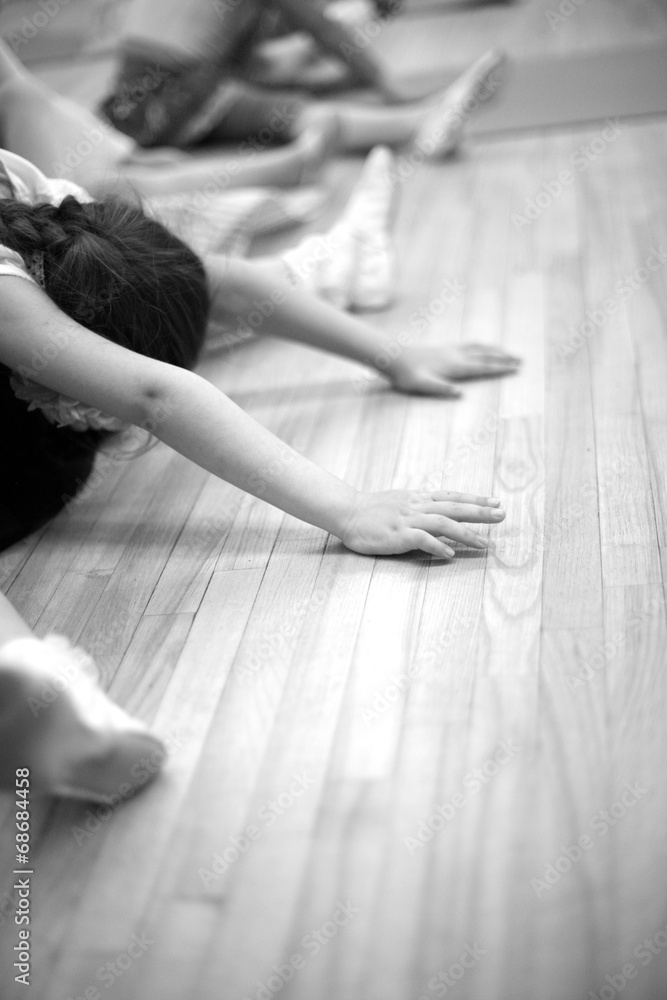 Girls stretching on the floor; monochrome