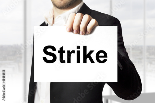 businessman holding sign strike