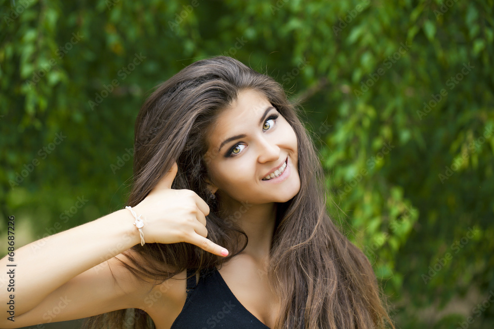 Beautiful woman making a call me gesture Beautiful woman making a call me gesture
