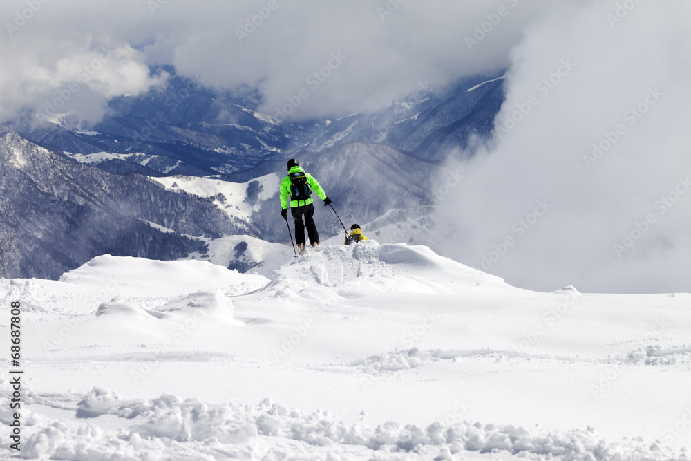 Freeriders on off-piste slope and mountains in mist