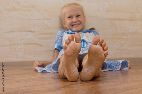 Obraz na płótnie Smiling Young Girl Showing Feet on Camera w salonie