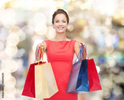 smiling elegant woman in dress with shopping bags