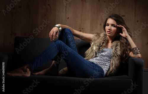 Portrait of elegant woman sitting on black sofa wearing a blue © lenets_tan