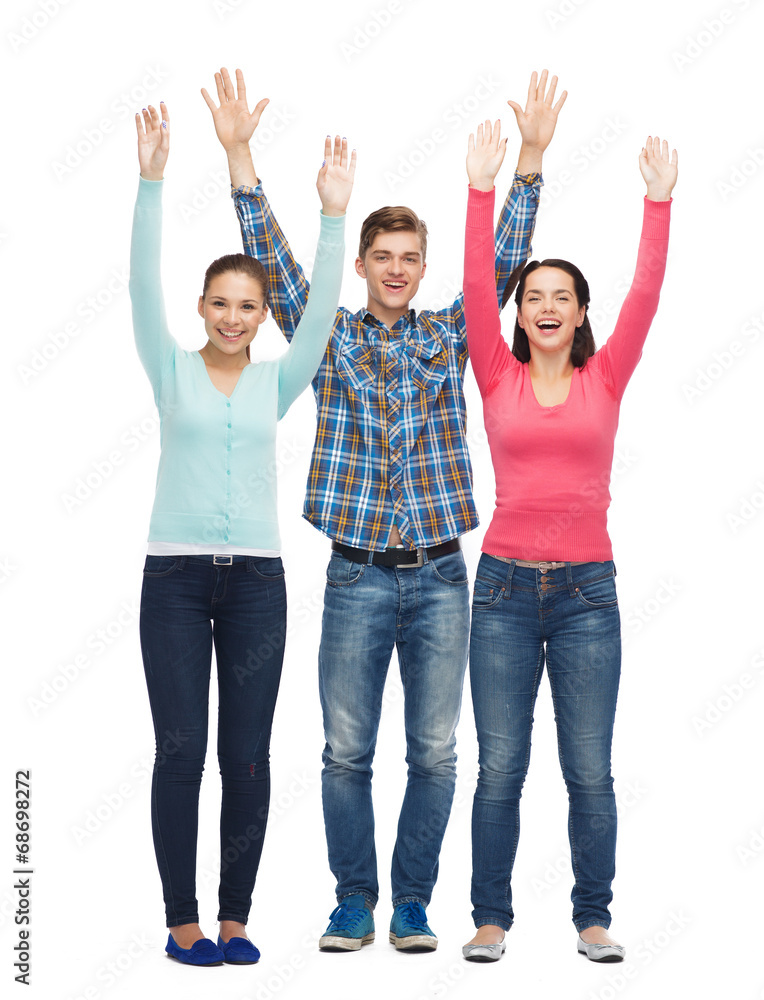 group of smiling teenagers with raised hands group of smiling teenagers with raised hands