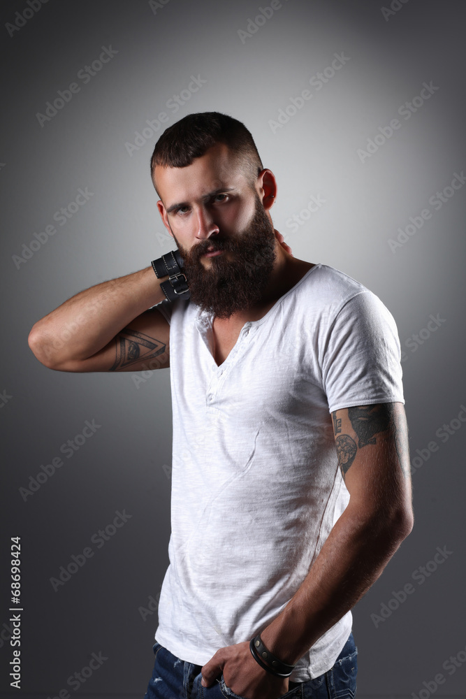 Portrait of handsome bearded man standing, isolated on grey Portrait of handsome bearded man standing, isolated on grey