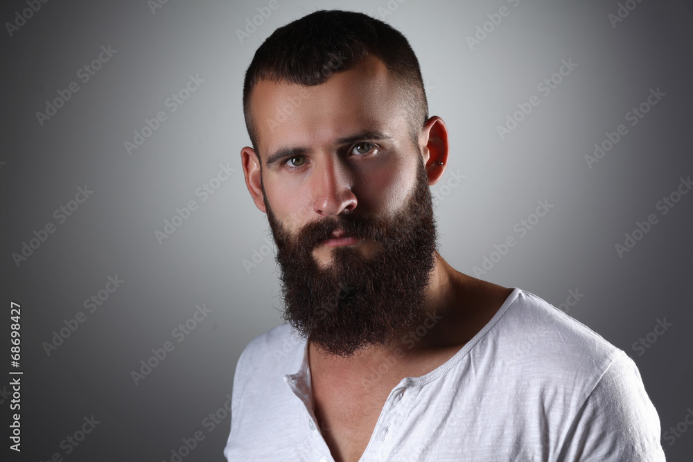 Portrait of handsome bearded man standing, isolated on grey Portrait of handsome bearded man standing, isolated on grey