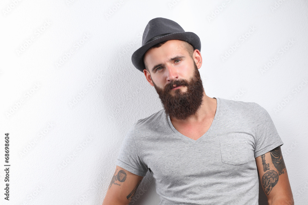 Portrait of handsome bearded man in hat standing , isolated on Portrait of handsome bearded man in hat standing , isolated on
