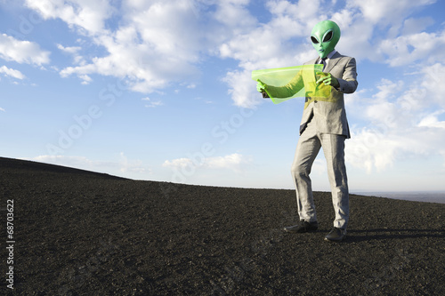 Φωτογραφία Alien Businessman Reading Map on Flexible Display Tablet