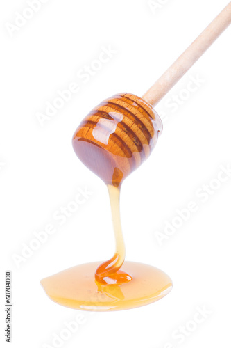Honey dripping from wooden dipper