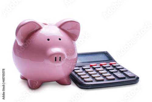 Pink porcelain piggy bank near a desk calculator