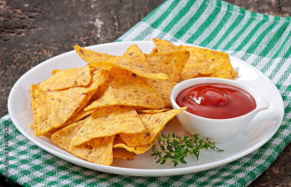 Nachos and tomato dip decorated with thyme leaves Nachos and tomato dip decorated with thyme leaves